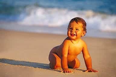 Bebé gateando en la playa