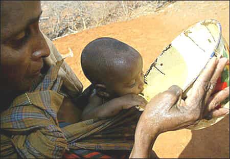 Bebé desfavorecido bebiendo agua