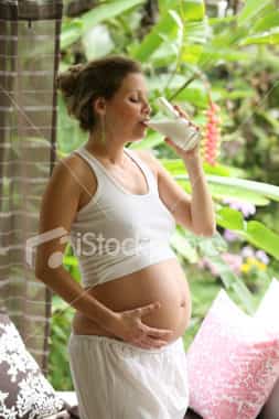 pregnant woman drinking milk in garden