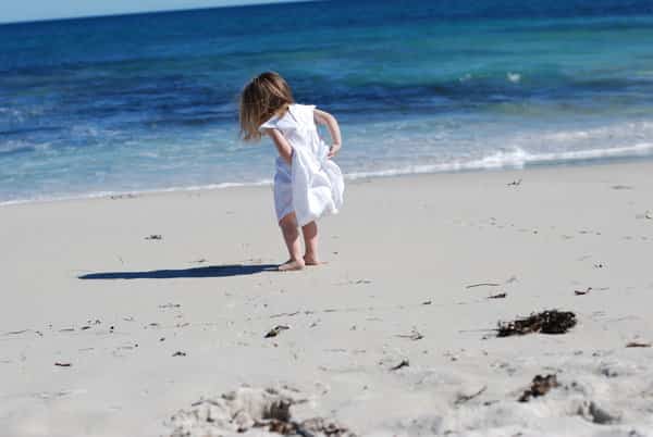 niña con vestido blanco en la playa