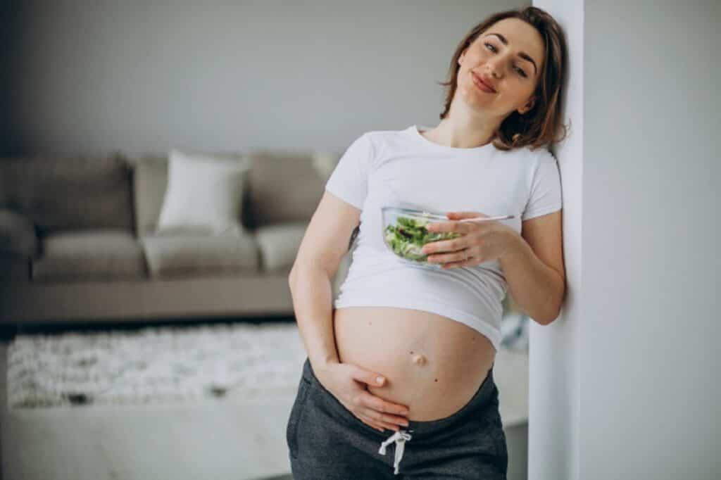 joven embarazada comiendo ensalada casa 1303 21123